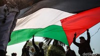 Massa membawa atribut seperti bendera Palestina.  