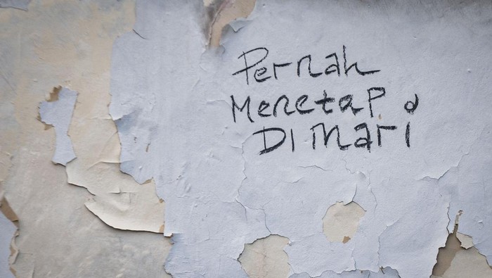 Seorang ibu bersama anaknya berjalan di sekitar rumah yang sudah ditinggali pemiliknya di Kampung Karian, Lebak, Banten.