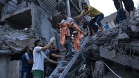 Warga Palestina menyelamatkan seorang anak dari reruntuhan bangunan di Gaza, Palestina, Selasa (10/10/2023). (AP Photo/Fatima Shbair)  