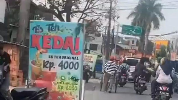 Pria berbaju hitam viral karena mengendari motor sambil duduk bersila, melintas di jalanan Kota Depok.