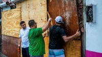 Di Puerto Vallarta, penduduk menutup jendela dan menyeret karung pasir dari pantai untuk memperkuat penghalang banjir di etalase toko mereka.  