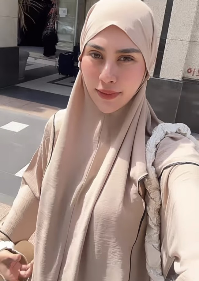 Penampilan Syahnaz juga terlihat cantik ketika mengenakan gamis dan khimar warna krem ketika pergi siang hari di Madinah. Ia hanya melengkapi gaya busananya dengan tas kecil warna putih yang simple.  Foto: Instagram @syahnaz