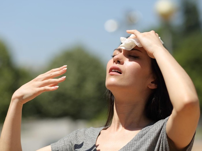 Asian woman drying sweat in a warm summer day