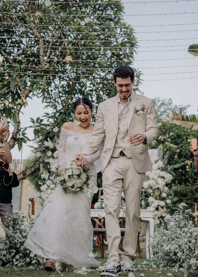 Penampilan Jennifer Coppen sendiri juga tampak simpel. Jennifer yang mengenakan gaun pengantin lengan panjang model sabrina itu tampak hanya mencepol rambutnya ke belakang. Riasan wajahnya pun tampak minimalis dan tak berlebihan. Foto: Instagram/@jennifercoppennreal20