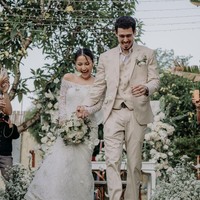 Penampilan Jennifer Coppen sendiri juga tampak simpel. Jennifer yang mengenakan gaun pengantin lengan panjang model sabrina itu tampak hanya mencepol rambutnya ke belakang. Riasan wajahnya pun tampak minimalis dan tak berlebihan. Foto: Instagram/@jennifercoppennreal20