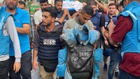 Seorang rekannya membawa jaket antipeluru berlumuran darah milik jurnalis Palestina Mohammed Soboh yang tewas.