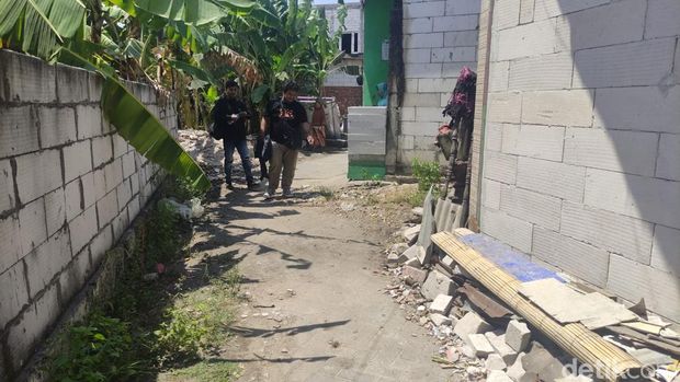 Masriah bersihkan dan bakar sampah yang sempat dibuangnya di depan jalan rumah Wiwik