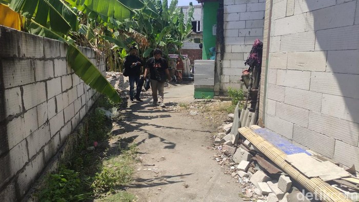 Masriah bersihkan dan bakar sampah yang sempat dibuangnya di depan jalan rumah Wiwik