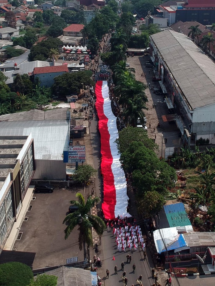 Meriahnya Kirab Merah Putih Sepanjang 100 Meter di Bogor Foto udara personel gabungan TNI Polri membawa bendera merah putih berukuran 5x100 meter saat Kirab Bendera Merah Putih di Cibinong, Kabupaten Bogor, Jawa Barat, Kamis (12/10/2023). Kirab Merah Putih tersebut merupakan salah satu rangkaian acara Maulid Akbar Nabi Besar Muhammad SAW dan Tausiah Kebangsaan 1445 H/2023 M di Bogor. ANTARA FOTO/Yulius Satria Wijaya/foc.