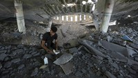 orang-orang nampak membereskan puing-puing masjid yang hancur, sambil mencari barang yang masih bisa diselematkan. Beberapa hari ini situasi di Gaza memanas usai Israel dan milisi Hamas saling serang.
