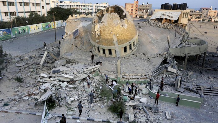 Penampakan Masjid Terkenal di Gaza yang Hancur Digempur Israel People stand outside a mosque destroyed in an Israeli air strike in Khan Younis, Gaza Strip, Sunday, Oct.8, 2023. The Hamas militants broke out of the blockaded Gaza Strip and rampaged through nearby Israeli communities, taking captives, while Israel's retaliation strikes leveled buildings in Gaza. (AP Photo/Yousef Masoud)