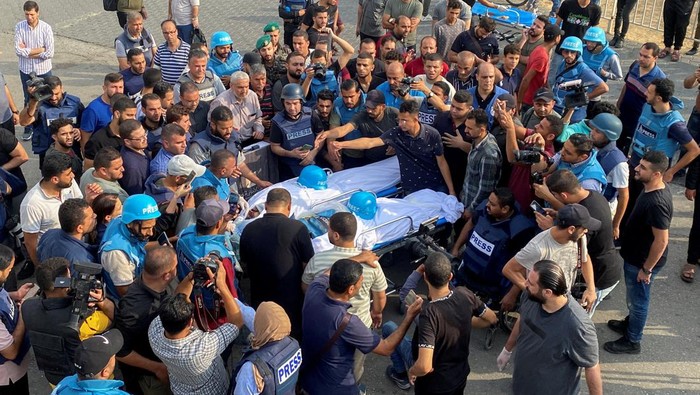 Pilu, Dua Jurnalis Palestina Tewas Saat Bertugas di Kota Gaza Mourners, including colleagues, carry the bodies of Palestinian journalists Mohammed Soboh and Saeed al-Taweel, who were killed when an Israeli missile hit a building while they were outside reporting, at a hospital in Gaza City, October 10, 2023. REUTERS/Arafat Barbakh