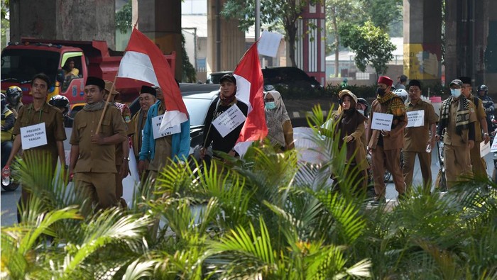 Sejumlah guru honorer dari Kabupaten Bekasi melakukan aksi jalan kaki menuju Istana Negara saat melintas di Cawang, Jakarta Timur, Kamis (12/10/2023). Aksi yang diikuti 40 guru Honorer yang tergabung dalam Forum Komunikasi Guru Honor Pendidikan Agama Islam (FKGHPAI) selama tiga hari tersebut untuk melaporkan dugaan maladministrasi di lingkungan Dinas Pendidikan Kabupaten Bekasi dengan tidak mengusulkan formasi Pegawai Pemerintah dengan Perjanjjian Kerja (PPPK) untuk pendidik mata pelajaran agama Islam. sejak tahun 2021. ANTARA FOTO/ Fakhri Hermansyah/foc.