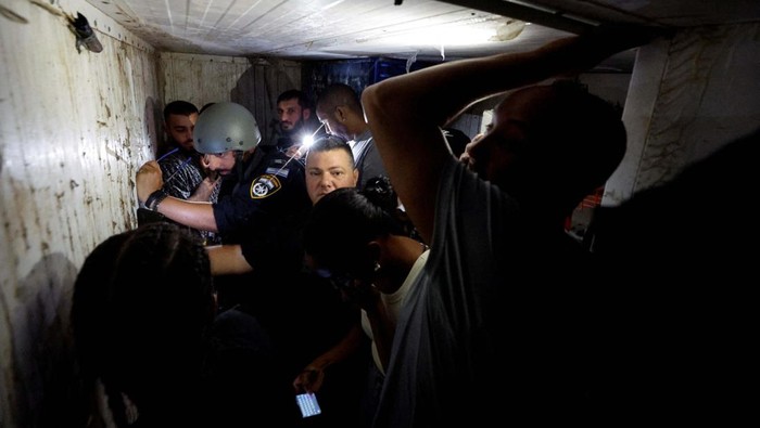 Rudal Hamas Tembus Ashkelon, Warga Israel Sembunyi di Bunker An Israeli military reservist helps residents of Ashkelon evacuate the city as he holds a rocket that was launched from the Gaza Strip and landed in Ashkelon, southern Israel, October 11, 2023. REUTERS/Amir Cohen TPX IMAGES OF THE DAY