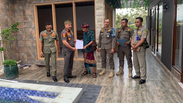 Satpol PP Jembrana melayangkan surat teguran ketiga terhadap pembangunan vila tanpa izin milik WNA di Pantai Pebuahan, Desa Banyubiru, Kecamatan Negara, Kabupaten Jembrana, Bali, Kamis (12/10/2023). (Foto: Dok. Satpol PP Jembrana)