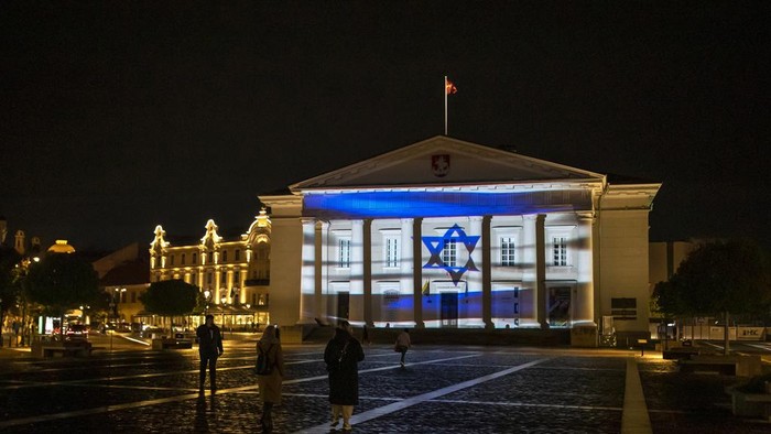 The Town Hall is illuminated with the colours of the Israeli flag, to underscore Lithuania's solidarity with Israel, in Vilnius, Lithuania, Wednesday, Oct. 11, 2023. (AP Photo/Mindaugas Kulbis)