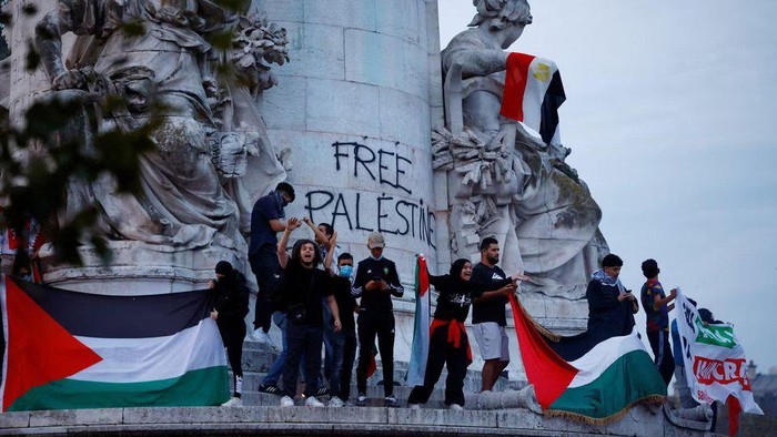 Protestors hold Palestinian flags during an unauthorized demonstration in support of Palestinians, as part of the ongoing conflict between Israel and the Palestinian Islamist group Hamas, at Place de la Republique in Paris as French Interior Minister Gerald Darmanin ordered the systematic banning of pro-Palestinian demonstrations and the arrest of participants within France, October 12, 2023. REUTERS/Sarah Meyssonnier Acquire Licensing Rights