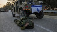 Seorang tentara Israel secara keliru mengira dia mendengar sirene serangan udara dan melompat ke tanah untuk berlindung di Kibbutz Beeri, Israel. Kibbutz dikuasai oleh militan Hamas dari Neraby Jalur Gaza pada Sabtu ketika mereka membunuh dan menangkap banyak orang Israel. AP/Ohad Zwigenberg  