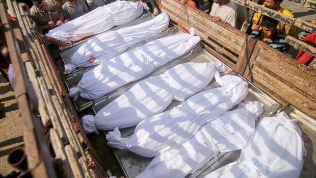Pelayat melihat jenazah keluarga Abu al-Rish yang tertutup, tewas dalam serangan udara Israel di Khan Yunis, di Jalur Gaza selatan pada 12 Oktober 2023. (Photo by SAID KHATIB / AFP)