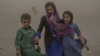 Tampak anak-anak ketakutan dan menangis saat mereka berusaha berlindung dari badai pasir.  