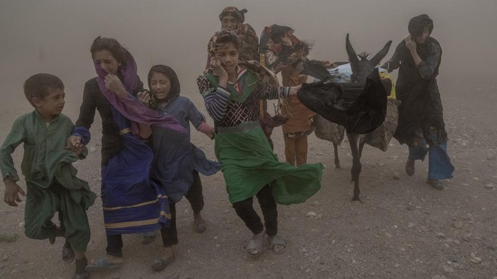Pilu, Anak-anak Korban Gempa Afghanistan Menangis Dihantam Badai Pasir An Afghan girl and woman receive aid, while they are scared and crying from the fierce sandstorm, after an earthquake in Zenda Jan district in Herat province, western of Afghanistan, Thursday, Oct. 12, 2023. Another strong earthquake shook western Afghanistan on Wednesday morning after an earlier one killed more than 2,000 people and flattened whole villages in Herat province in what was one of the most destructive quakes in the country's recent history. (AP Photo/Ebrahim Noroozi)