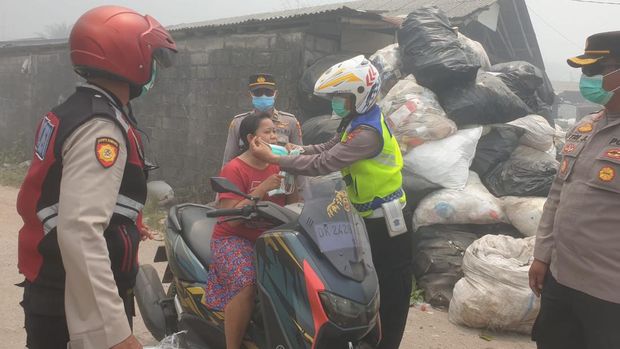 Polisi membagikan masker kepada warga yang terdampak kebakaran TPA Suwung. (Dok. Polresta Denpasar)