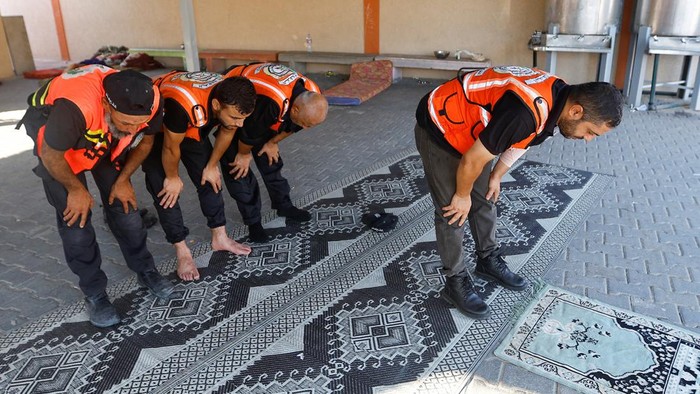 Potret Tim Penyelamat Salat Jemaah di Tengah Serangan Israel ke Gaza Tim penyelamat Palestina tetap beribadah di tengah kesibukannya mengevakuasi warga yang terjebak reruntuhan akibat perang Hamas vs Israel. Ini potretnya.