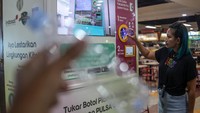 Pengunjung menukarkan sampah plastik dengan pulsa dari operator seluler IM3 dan Tri melalui Reverse Vending Machine (RVM) Plasticpay di pusat perbelanjaaan Bogor Trade Mall (BTM), Kota Bogor, Jawa Barat, Jumat (13/10/2023).