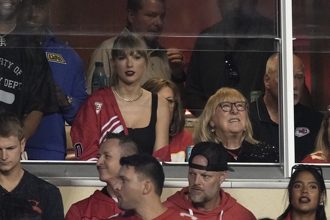 Taylor Swift menunjukkan dukungannya dengan memakai jaket merah-putih, warna dari tim football Travis Kelce, Kansas City Chiefs. Penyanyi 33 tahun ini menyampirkan jaket di bahu kanan, di atas tank top hitam. Foto: AP/Charlie Riedel