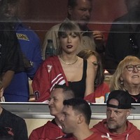 Taylor Swift menunjukkan dukungannya dengan memakai jaket merah-putih, warna dari tim football Travis Kelce, Kansas City Chiefs. Penyanyi 33 tahun ini menyampirkan jaket di bahu kanan, di atas tank top hitam. Foto: AP/Charlie Riedel