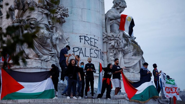 Unjuk Rasa Warga di Prancis Dukung Kemerdekaan Palestina Protestors hold Palestinian flags during an unauthorized demonstration in support of Palestinians, as part of the ongoing conflict between Israel and the Palestinian Islamist group Hamas, at Place de la Republique in Paris as French Interior Minister Gerald Darmanin ordered the systematic banning of pro-Palestinian demonstrations and the arrest of participants within France, October 12, 2023. REUTERS/Sarah Meyssonnier
