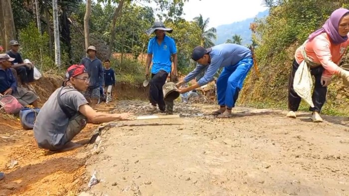 Warga Dusun Linggamanik Desa Bojongkapol Kecamatan Bojonggambir Kabupaten Tasikmalaya, bergotong royong memperbaiki kerusakan jalan.
