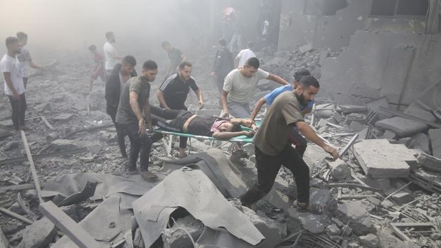 Warga Palestina mengevakuasi orang-orang yang terluka pasca serangan udara Israel di kamp pengungsi Rafah, Jalur Gaza selatan, Kamis, 12 Oktober 2023. (AP Photo/Hatem Ali)