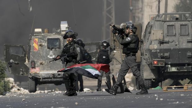Israeli soldiers fire tear gas at Palestinians in the Gaza Strip city of Nablus, West Bank, Friday, October 13, 2023. (AP Photo/Majdi Mohammed)
