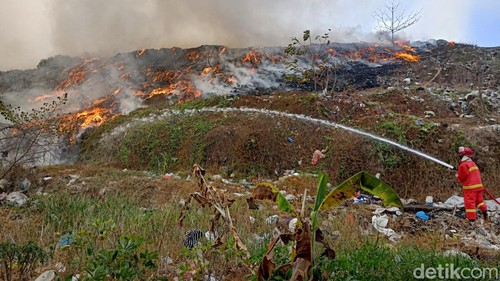 Petugas pemadam kebakaran memadamkan api pada bukit sampah di TPA Mandung yang kebakaran pada hari ini, Sabtu (14/10/2023).