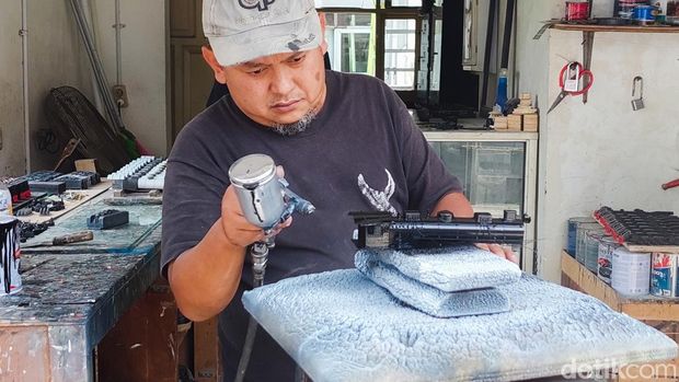 Seorang Pekerja Mengecat Rangka Miniatur Kereta Api di Workshop Milik Eddy Mardijanto