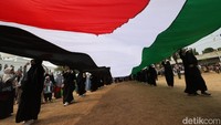Massa juga sempat mengibarkan bendera Palestina raksasa.