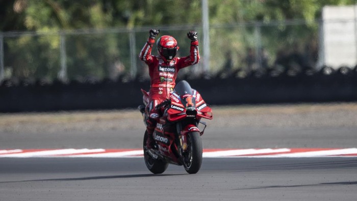 Pembalap Ducati Lenovo Team Francesco Bagnaia  mengangkat tangan di podium seusai menjuarai balapan MotoGP seri ke-15 di Pertamina Mandalika International Street Circuit, Lombok Tengah, NTB, Minggu (15/10/2023). Francesco Bagnaia menjuarai MotoGP Mandalika setelah menyelesaikan 27  lap dengan catatan waktu 41 menit 20,293 detik disusul pembalap Aprilia Racing Maverick Vinales dan pembalap Monster Energy Yamaha Fabio Quartararo. ANTARA FOTO/Wahyu Putro A/NZ