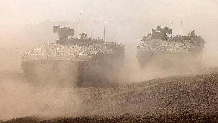 Israeli army Namer armoured personnel carriers (APCs) deploys with others along the border with the Gaza Strip in southern Israel on October 13, 2023. Thousands of people, both Israeli and Palestinians have died since October 7, 2023, after Palestinian Hamas militants entered Israel in a surprise attack leading Israel to declare war on Hamas in the Gaza Strip enclave on October 8. (Photo by Menahem KAHANA / AFP)