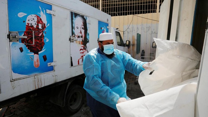ISRAEL-PALESTINIANS/ Medical personnel works on carrying the bodies of Palestinians, who were killed in Israeli strikes, from an ice cream truck where they were kept, as the hospital morgues are packed, amid the ongoing Israeli-Palestinian conflict, in the central Gaza Strip October 15, 2023. REUTERS/Stringer
