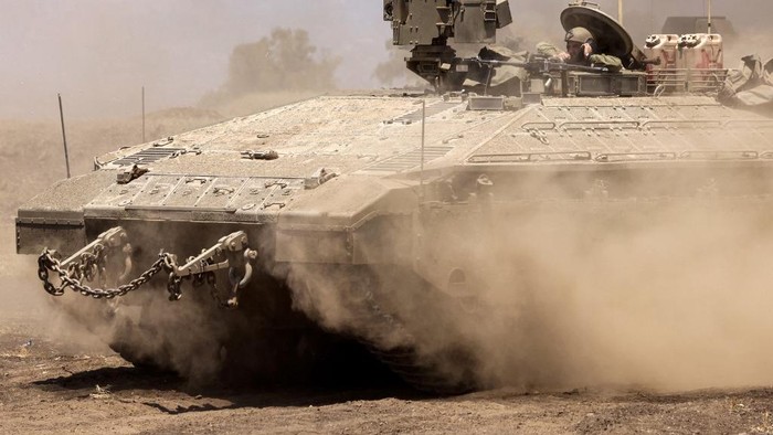 Israeli army Namer armoured personnel carriers (APCs) move in a convoy as they are redeployed back into Israel from the occupied West Bank at the border crossing near Muqeibila on July 4, 2023. Israel's biggest military operation for years in the occupied West Bank continued for a second day on July 4, leaving at least 10 Palestinians dead and forcing thousands to flee their homes as the government said it struck 