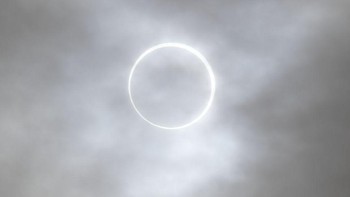 Namun memang berbeda-beda pengalaman yang dirasakan di setiap tempat. Salah satunya Tayfun Coskum, seorang fotografer, yang mengabadikan gerhana yang diselimuti oleh awan tipis. Foto: (Tayfun Coskun/Anadolu via Getty Images).