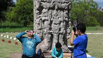 Adapula yang mencoba melihat gerhana bersama dengan keluarganya, seperti foto yang diambil Orlando Sierra, seorang fotografer, di Observatorium Astronomi Universitas Otonomi Nasional di Honduras. Foto: (Orlando Sierra/AFP/Getty Images).
