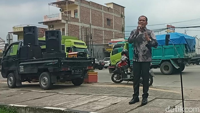 Anggota DPRD Sumut Zainuddin Purba saat melakukan orasi tunggal di depan Mapolda Sumut. (Angelina Giyanti Purba/detikSumut)