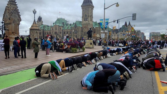 Dukung Palestina, Warga Kanada Salat Berjamaah di Depan Gedung Parlemen People pray in front of Parliament Hill in support of Palestinians, as Israeli troops prepared to move into the Gaza Strip in pursuit of Hamas militants who had rampaged through Israeli towns, in Ottawa, Ontario, Canada October 15, 2023. REUTERS/Ismail Shakil
