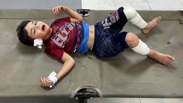 A Palestinian woman reacts next to a girl who was wounded in an Israeli strike, at Shifa hospital in Gaza City, October 15, 2023. REUTERS/Mohammed al-Masri