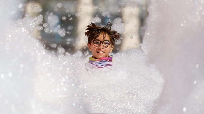 Keseruan Lomba Lari Sambil Mandi Busa di Malta A participant runs through a foam bath during the 'Colour My Run' charity fun run in Ta' Xbiex, Malta October 15, 2023. REUTERS/Darrin Zammit Lupi