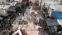Pemandangan udara menunjukkan awak media saat berkunjung ke Kibbutz Kfar Aza, pasca serangan oleh Hamas, Minggu (15/10/2023).