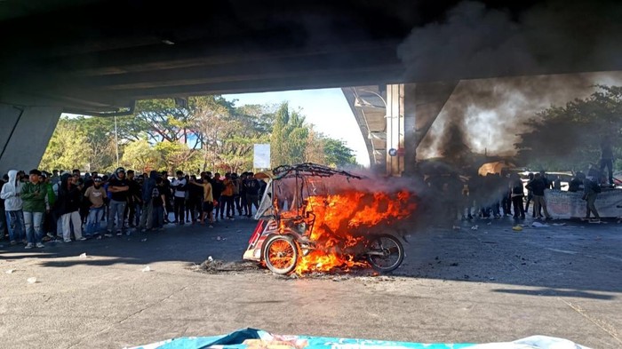 Sejumlah massa melakukan demonstrasi mengawal putusan Mahkamah Konstitusi (MK) terkait batas usia capres dan cawapres di fly over Makassar, Sulawesi Selatan (Sulsel). Demo tersebut diwarnai dengan aksi pembakaran becak motor (bentor).