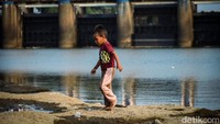 Bagian dasar sungai terlihat dan dimanfaatkan anak-anak untuk bermain.  